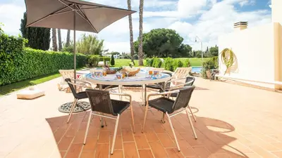 a table with chairs and an umbrella on a patio at Vilamoura - VILLA LIMONI in Vilamoura