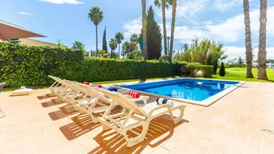 a swimming pool with lounge chairs next to a swimming pool at Vilamoura - VILLA LIMONI in Vilamoura