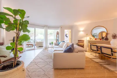 a living room with a white couch and a plant at Jardins do Golfe at Vale do Lobo in Vale do Lobo