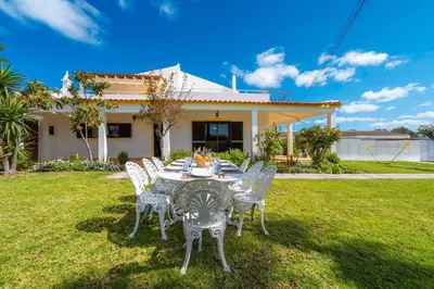a table and chairs in front of a house at Villa 4 Quartos, Piscina, AC, Jardim, Prestige For Home in Loulé