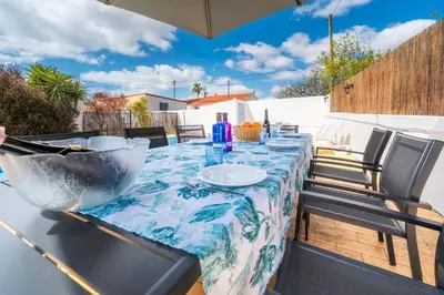 a table with a blue and white table cloth on a patio at Villa 4 Quartos, Piscina, AC, Jardim, Prestige For Home in Loulé