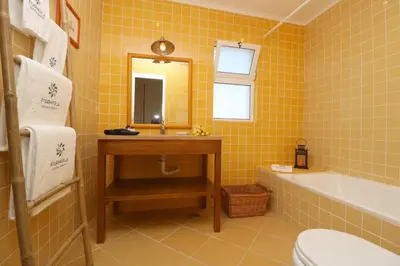 a bathroom with a tub and a sink and a mirror at Villa Vilamoura, piscina privada in Quarteira