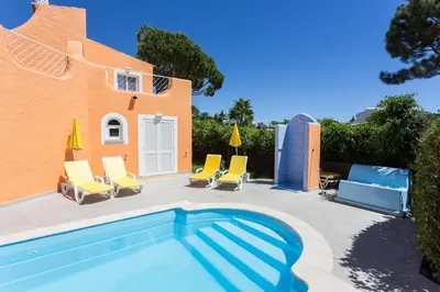 a villa with a swimming pool and chairs at Toiago in Vilamoura