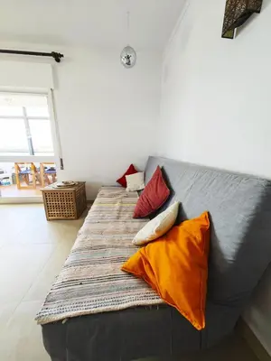 a couch with four pillows on it in a room at Blife Paulya private apartment in Faro