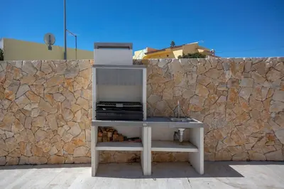 a laptop sitting on a desk next to a stone wall at Beautiful Villa with a Pool in Albufeira