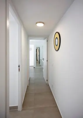 a hallway with white walls and a clock on the wall at Beautiful Villa with a Pool in Albufeira