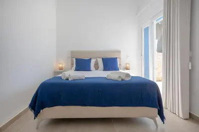 a white bedroom with a blue bed with blue pillows at Beautiful Villa with a Pool in Albufeira