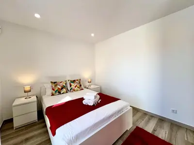 a bedroom with a large bed with a red blanket at Vilamoura Design 2 by Homing in Vilamoura