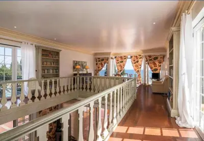 a staircase in a home with windows and bookshelves at Casa da Vigia - waking up in front of the sea in Albufeira