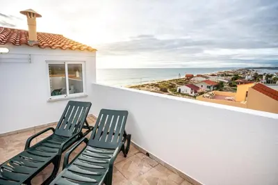 two chairs on a balcony with a view of the ocean at Blife Benya private apartment in Faro