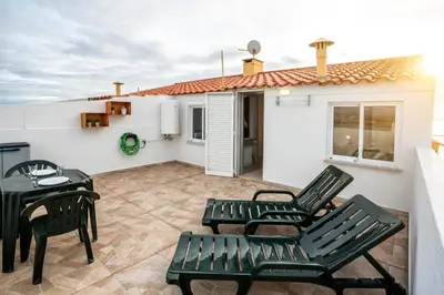a patio with chairs and a table and a house at Blife Benya private apartment in Faro