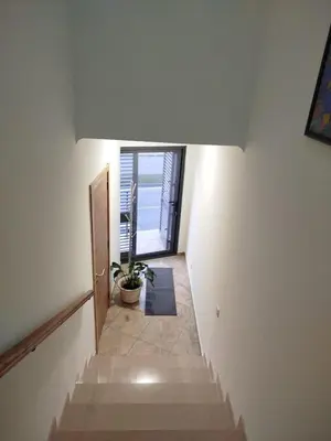 a hallway with stairs with a potted plant and a door at Fernandes Holidays in Quarteira