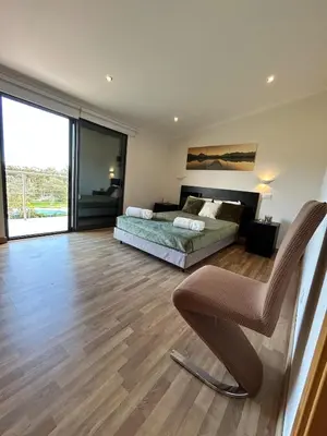 a bedroom with a bed and a chair at Fernandes Holidays in Quarteira