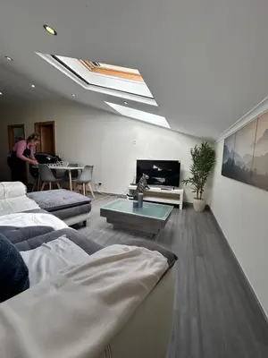a living room with a skylight and a couch and a table at Fernandes Holidays in Quarteira