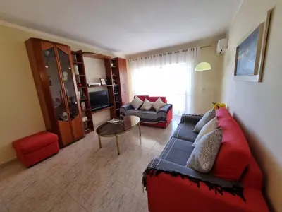 a living room with a red couch and a table at TAC - Bright Coast Quarteira in Quarteira