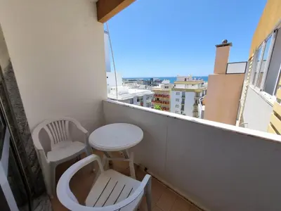 a balcony with two chairs and a table and a window at TAC - Bright Coast Quarteira in Quarteira