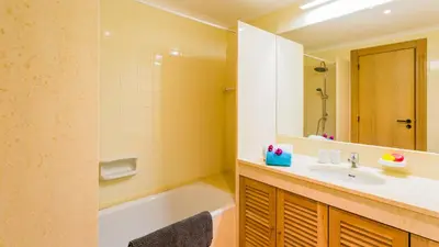 a bathroom with a tub and a sink and a mirror at SomeSunnyDay Vila Sol Village in Quarteira