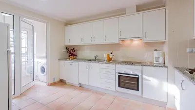 a kitchen with white cabinets and a stove top oven at SomeSunnyDay Vila Sol Village in Quarteira