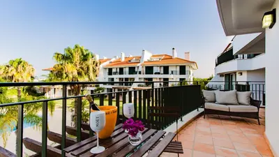 a balcony with a table with a bottle of wine at SomeSunnyDay Vila Sol Village in Quarteira