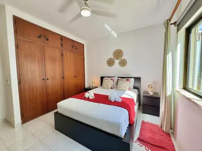 a bedroom with a large bed with a red blanket at Vilamoura Golf Apartment 2 With Pool by Homing in Vilamoura