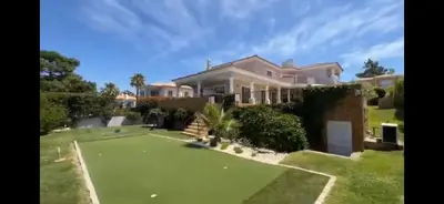a house with a golf course in front of it at The Beverly Vilamoura in Quarteira
