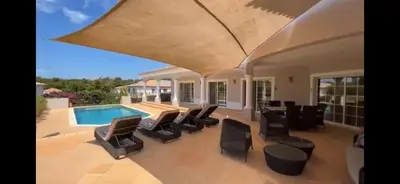 a patio with black chairs and a swimming pool at The Beverly Vilamoura in Quarteira