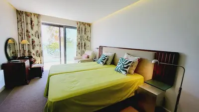 a room with a dresser and a mirror and a chair at Casa da Praia By Garvetur in Albufeira