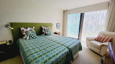 a bedroom with a bed and a couch and a window at Casa da Praia By Garvetur in Albufeira