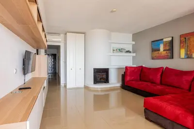 a living room with a red couch and a fireplace at Beachfront apartment Praia dos Aveiros in Albufeira