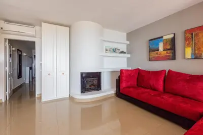 a living room with a red couch and a fireplace at Beachfront apartment Praia dos Aveiros in Albufeira