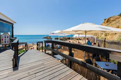 a wooden boardwalk leading to a beach with umbrellas at Beachfront apartment Praia dos Aveiros in Albufeira