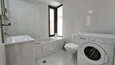 a white bathroom with a toilet and a washing machine at Albufeira, Blue Wave Retreat 64 in Albufeira