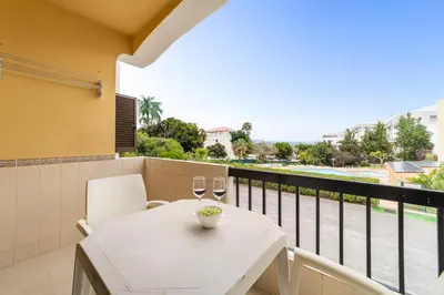 a balcony with a table and two glasses of wine at Passport Beach - 201 by HelloVacations in Albufeira