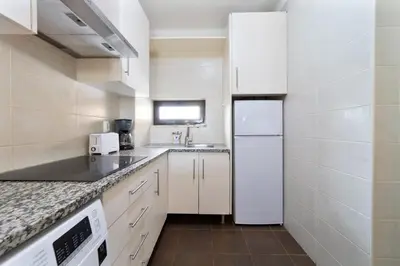 a kitchen with white appliances and a white refrigerator at Passport Beach - 201 by HelloVacations in Albufeira