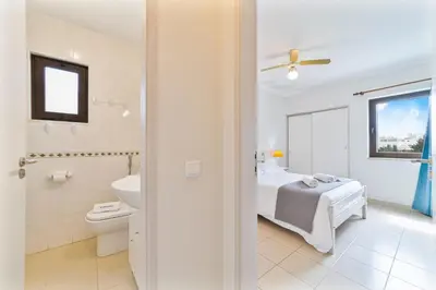 a bedroom with a bed and a toilet and a bathroom at Passport Beach - 201 by HelloVacations in Albufeira