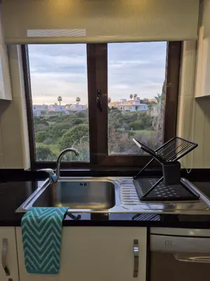 a kitchen with a sink and a laptop on a window at Apartamento T2 86B na Praia Sao Rafael, Vista Mar - Albufeira in Albufeira