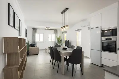 a kitchen and dining room with a table and chairs at Flores 2Bedroom Apartment - Sea view Quarteira in Quarteira