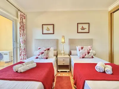a bedroom with two beds with red sheets at Vilamoura Lovely Beach Stay With Pool by Homing in Vilamoura