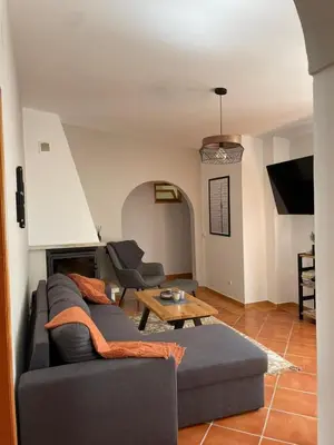 a living room with a couch and a table at Quinta da Calma with pool and BBQ in Boliqueime