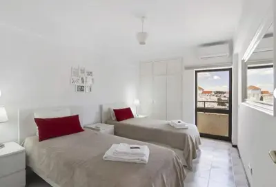 a white room with two beds and a window at Algarve Paraíso Casa Solimô in Bicas
