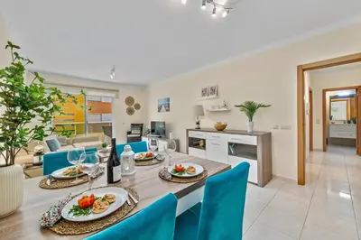 a dining room and kitchen with a table and chairs at Pool with Beach 10' Away - Comfort and Tranquility in Quarteira