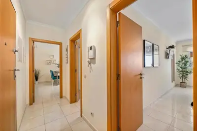 a hallway with a door and a room with a table at Pool with Beach 10' Away - Comfort and Tranquility in Quarteira