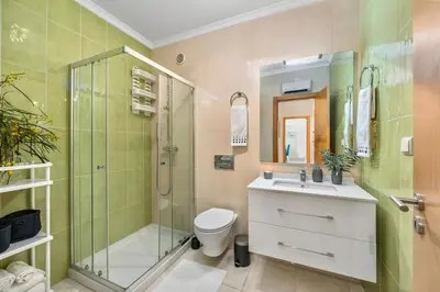 a bathroom with a shower and a toilet and a sink at Pool with Beach 10' Away - Comfort and Tranquility in Quarteira