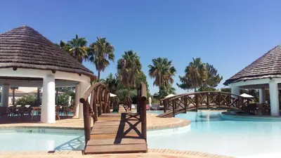 a bridge over a pool at a resort at Beautiful 2 Bedroom Self Catering Apartment with Private Pool and Garden in the Encosta do Lago Resort in Quinta do Lago in Quinta do Lago