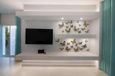 a living room with butterflies on the wall at Beautiful 2 Bedroom Self Catering Apartment with Private Pool and Garden in the Encosta do Lago Resort in Quinta do Lago in Quinta do Lago