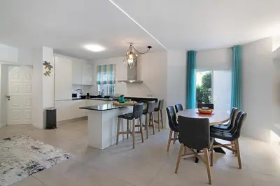 a kitchen and dining room with a table and chairs at Beautiful 2 Bedroom Self Catering Apartment with Private Pool and Garden in the Encosta do Lago Resort in Quinta do Lago in Quinta do Lago