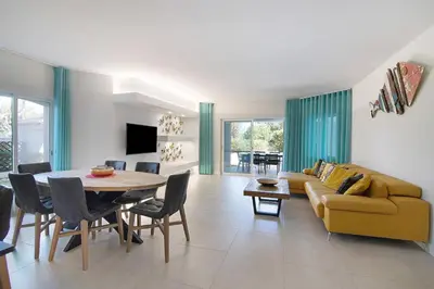 a living room with a yellow couch and a table at Beautiful 2 Bedroom Self Catering Apartment with Private Pool and Garden in the Encosta do Lago Resort in Quinta do Lago in Quinta do Lago