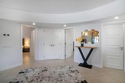 a room with white walls and white doors and a table at Beautiful 2 Bedroom Self Catering Apartment with Private Pool and Garden in the Encosta do Lago Resort in Quinta do Lago in Quinta do Lago