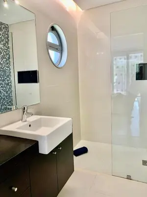 a white bathroom with a sink and a mirror at Vila orada lola in Albufeira