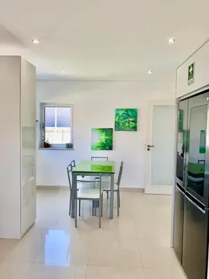 a kitchen and dining room with a table and chairs at Vila orada lola in Albufeira